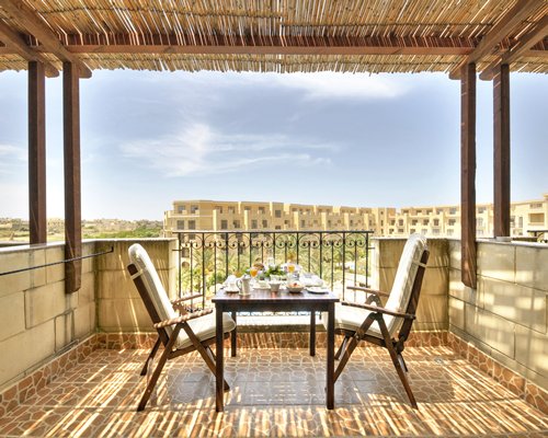 A balcony with dining setup alongside the San Lawrenz Leisure Resort.