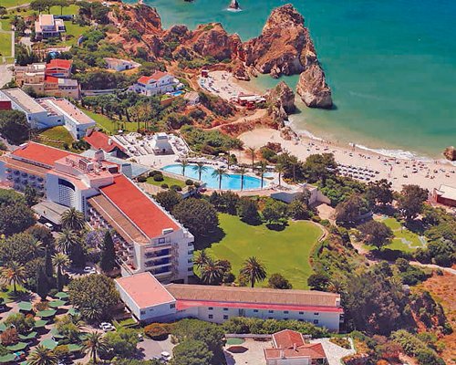 An aerial view of Pestana Alvor Beach Club with outdoor swimming pool and landscaping alongside the beach.