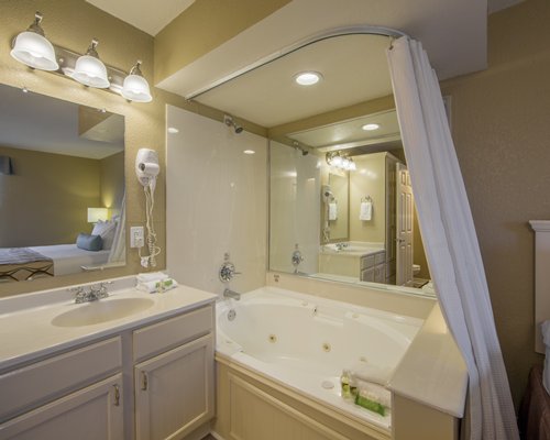 A bathroom with a shower stand sink and a vanity.