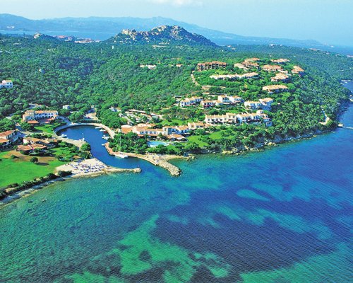 An aerial view of the resort properties surrounded by wooded area alongside the sea.