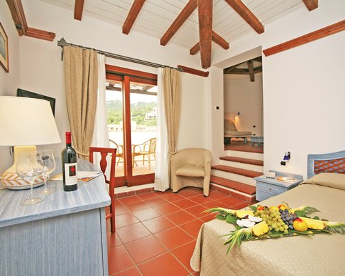 A well furnished bedroom with a television and balcony.