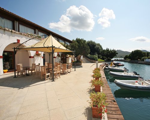 View of Domina Home Palumbalza with outdoor dining alongside the waterfront with boats.