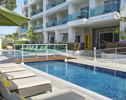 An outdoor swimming pool with chaise lounge chairs.