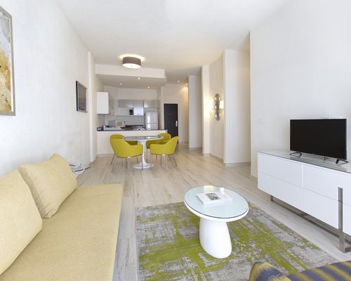 An open plan living dining and kitchen with a television.