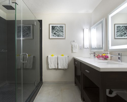 A bathroom with stand up shower and double sink vanity.