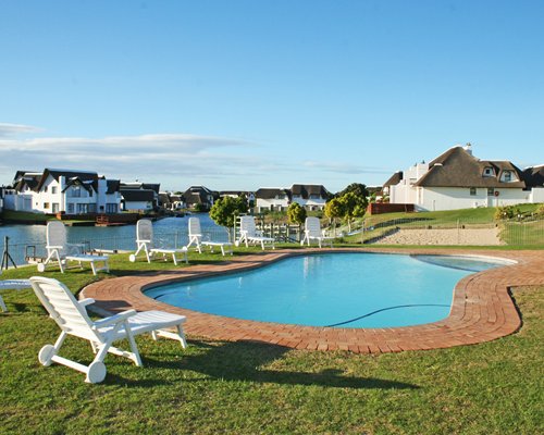 An outdoor swimming pool with chaise lounge chairs.