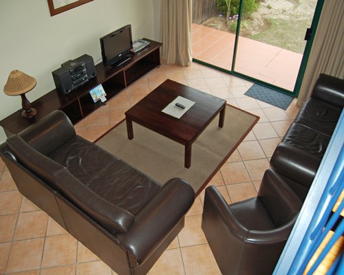 A view of well furnished living room with a television and boom box.