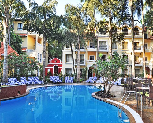 A view of an outdoor swimming pool with chaise lounge chairs alongside the resort.