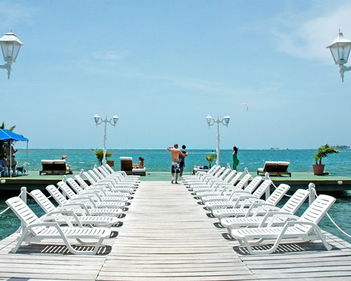 View of chaise lounge chairs on a pier at the beach.
