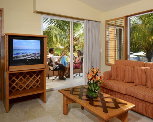 A well furnished living room with a television and a balcony.
