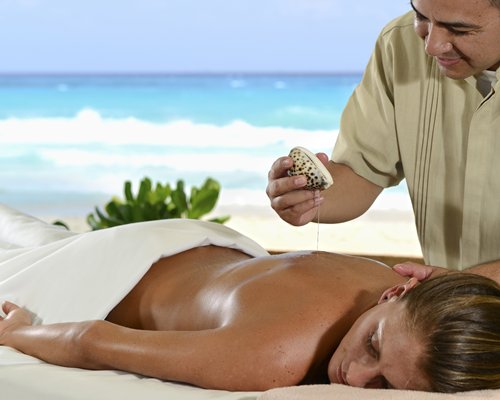 A woman enjoying a massage in an outdoor spa facility.