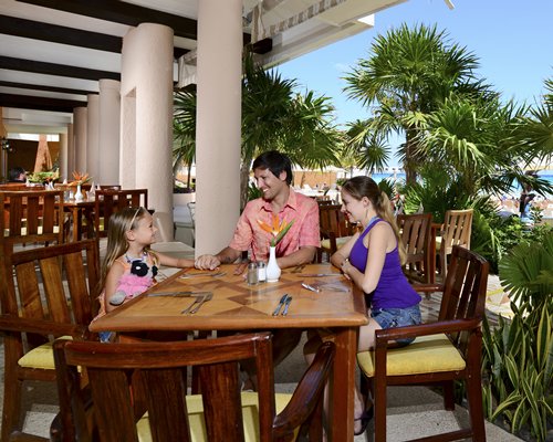 A family in an indoor fine dining area at the Sunset Fishermen Spa & Resort.
