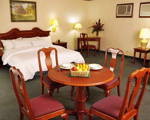 A well furnished bedroom with king bed and dining area.