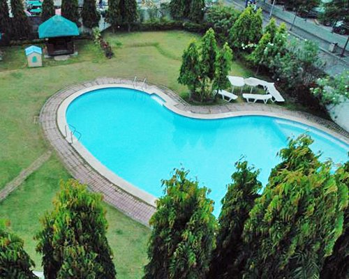 An outdoor swimming pool with chaise lounge chairs.