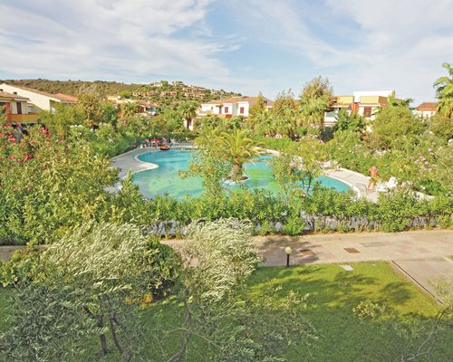 An outdoor swimming pool surrounded by trees alongside the resort.