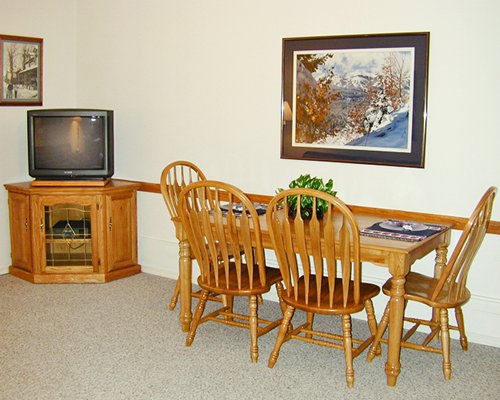 A well furnished dining area with a television.