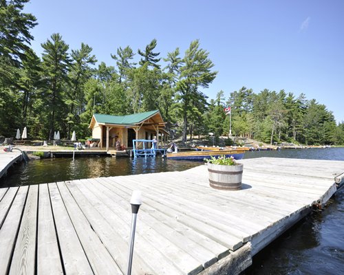 A view of wooden pier leading to the lake alongside the boats.