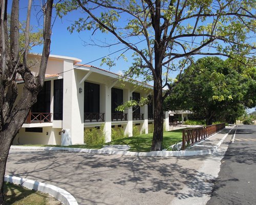 Street view of Coronado Golf & Beach Resort with trees.