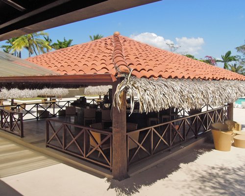 An outdoor restaurant alongside a swimming pool.