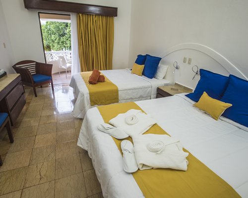 A well furnished bedroom with two beds and a balcony.