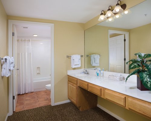 A bathroom with bathtub and a single sink vanity.