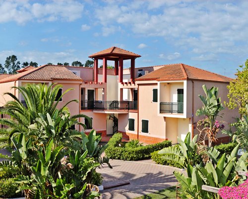 An exterior view of multi story resort units alongside trees.