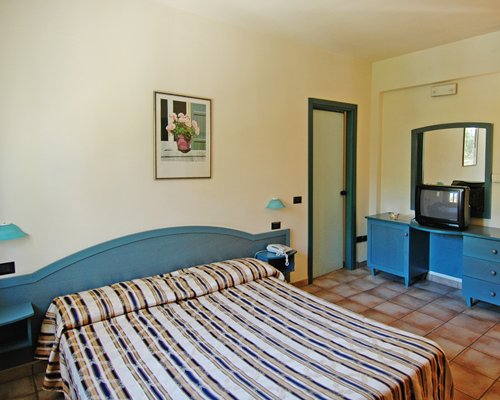 A well furnished bedroom with double bed and television.