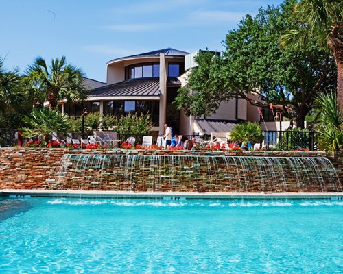 Outdoor cascade pool with chaise lounge chairs.