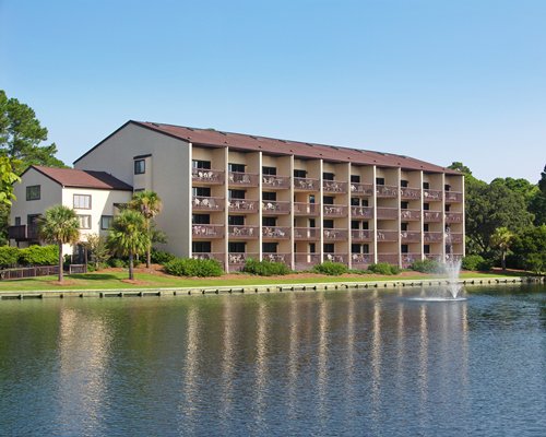 An exterior view of multi story resort units alongside a waterfront.