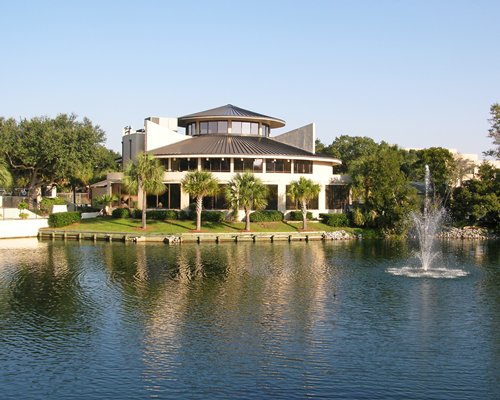 Scenic exterior view of Island Club alongside the waterfront with a fountain.