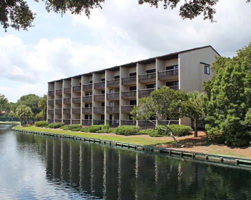 Scenic exterior view of Island Club with multiple balconies alongside a waterfront.