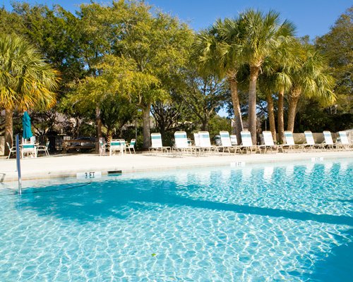 Outdoor swimming pool with chaise lounge chairs .