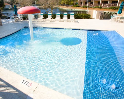 Outdoor swimming pool with mushroom umbrella near the freshwater lagoon.