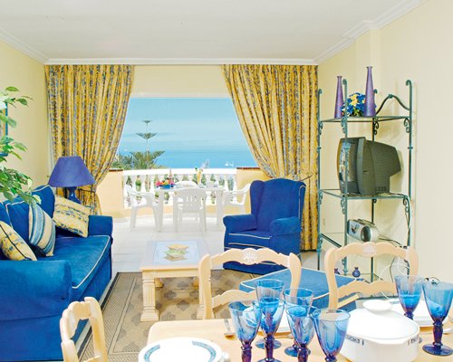 A well furnished living room with dining area balcony and ocean view.