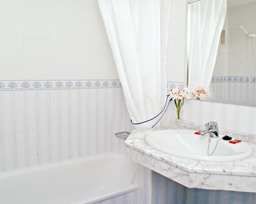 A bathroom with a single sink vanity and a bathtub.