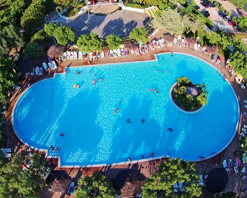An aerial view of large outdoor swimming pool with chaise lounge chairs.