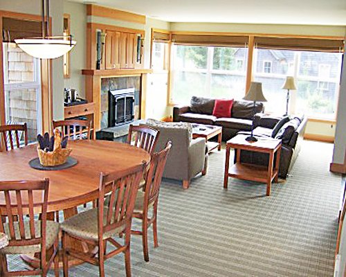 An open plan living and dining area with a pull out sofa and fireplace.