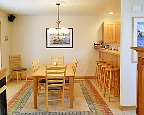 A well furnished dining area alongside kitchen with a breakfast bar.