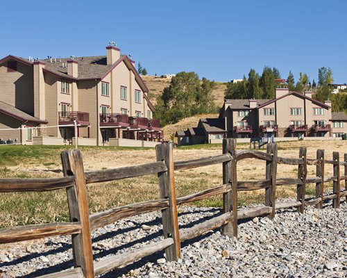 An exterior view of multiple resort units surrounded by trees.