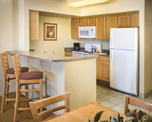 An open plan kitchen with breakfast bar and dining area.