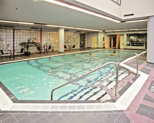 Indoor swimming pool with patio chairs.