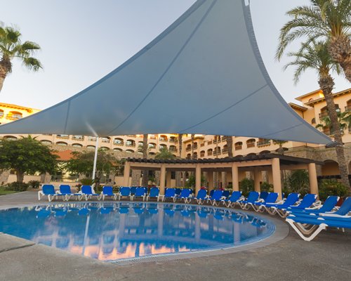 Small resort pool with lounge chairs and shade canopy