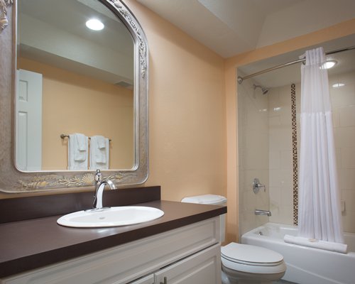 A bathroom with a shower bathtub and single sink vanity.