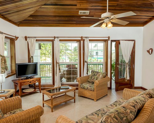 A well furnished living room with television and balcony.