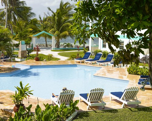 An outdoor swimming pool with chaise lounge chairs.