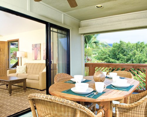 A well furnished dining room with an outside view alongside the living room.