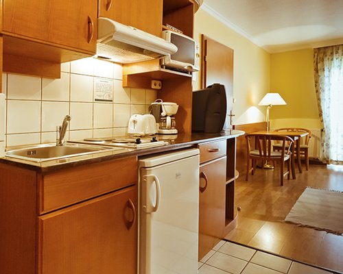 A well equipped kitchen alongside the dining area with a television.
