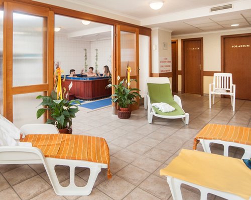 An indoor hot tub with chaise lounge chair.
