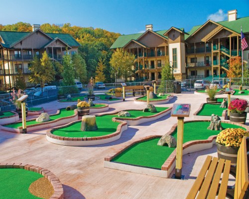 AN OUTDOOR RECREATION AREA WITH MINI GOLF COURSE ALONGSIDE MULTIPLE UNITS.