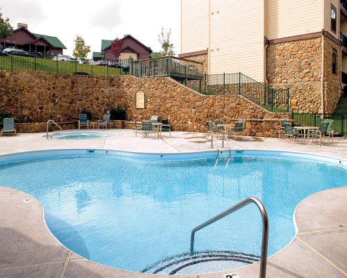 OUTDOOR SWIMMING POOL WITH CHAISE LOUNGE CHAIRS.